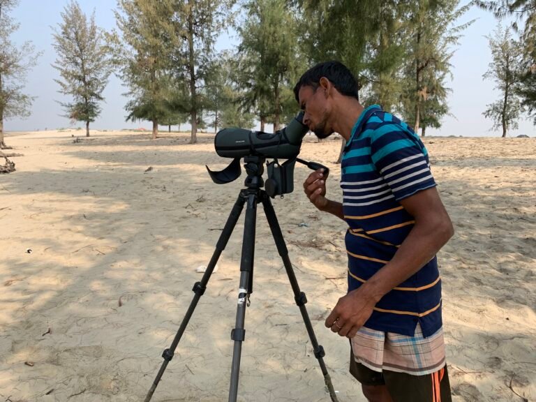 Curious local fishermen looking through spotting scope